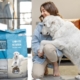 Image of a person and their dog looking at a package of pet food.