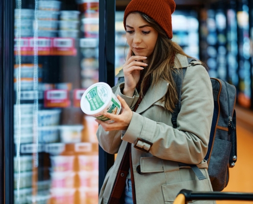 Image of a person at a grocery store, reading a food label.