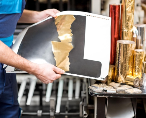 Image of a worker reviewing gold foil stamping.