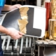 Image of a worker reviewing gold foil stamping.