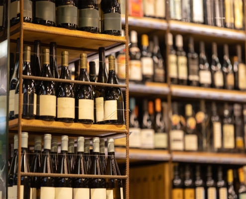 Side view of a large amount of wine bottles on multiple shelves