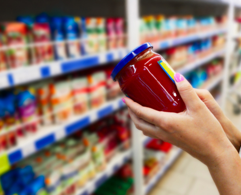 Glass jar of sauce in the hands of the buyer